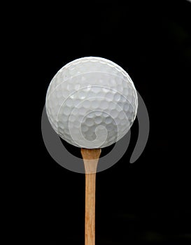 Golf ball on tee on black