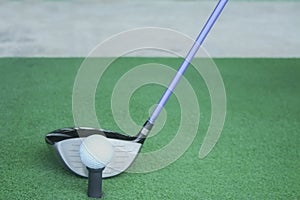 Golf ball on tee with driver club, in front of driver, driving r