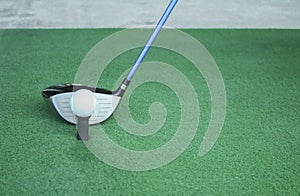 Golf ball on tee with driver club, in front of driver, driving r