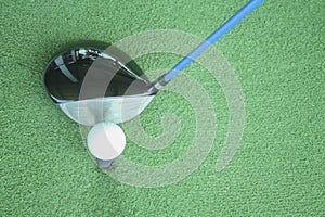 Golf ball on tee with driver club, in front of driver, driving r