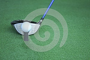 Golf ball on tee with driver club, in front of driver, driving r