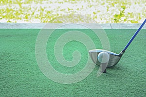 Golf ball on tee with driver club, in front of driver, driving r