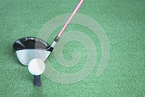 Golf ball on tee with driver club, in front of driver, driving r