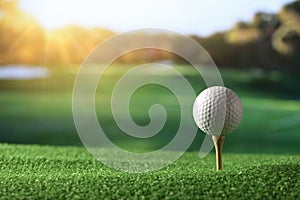 Golf ball on tee with fairway golf course