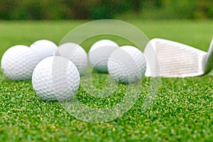 Golf ball on tee in front of driver green course