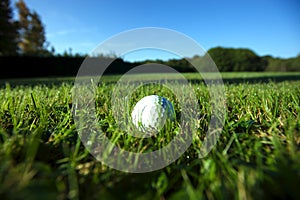 Golf ball on wet lush fairway