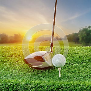 golf ball on a white tee next to a golf club on a grassy field. close-up view