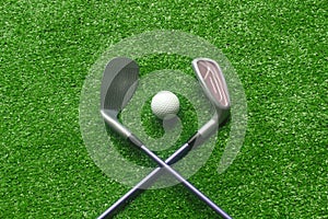 Golf balls and golf clubs on green grass.