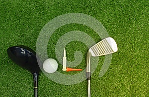 Golf balls and golf clubs on green grass