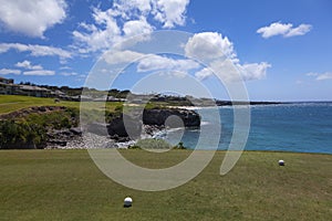 Golf balls on green on ocean front course in Maui, Hawaii