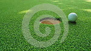 Golf balls with hole on green grass