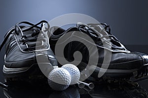 Golf balls, tees and shoes on dark blue background.