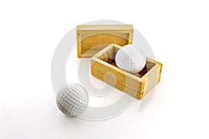 Golf balls in wooden boxes on a white background.