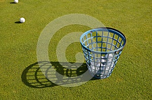 golf basket, golf balls, green field