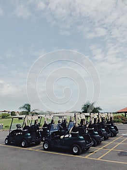 Golf cars on car parking of Altos de Chavon under blue sky with small clouds photo