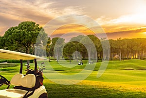 Golf cart on beautiful golf course at sunset