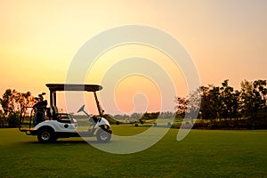 Golf cart car in fairway of golf course with fresh green grass field