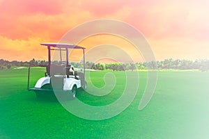 Golf cart car in fairway of golf course with fresh green grass field and cloud sky background