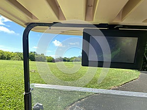 Golf cart on fairway of golf course with green grass field and navigator map. golf and car