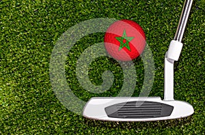 A golf club and a ball with flag Morocco during a golf game