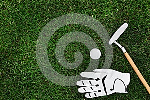 Golf club, ball and glove on green grass, flat lay