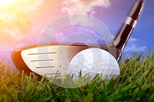 Golf club and ball in grass