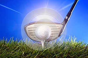 Golf club and ball in grass