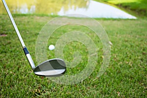 Golf club and ball in grass