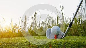 Golf club and ball in green grass. Golf balls on the golf course with golf clubs ready for golf in the first short