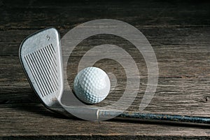 Golf club and ball on old wood
