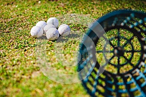Golf club and balls in grass
