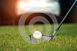 golf club and golf ball close up in grass field with sunset. Golf ball close up in golf coures