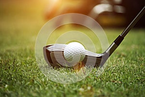 golf club and golf ball close up in grass field with sunset. Golf ball close up in golf coures