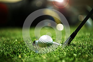 golf club and golf ball close up in grass field with sunset. Golf ball close up in golf coures