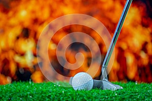 Golf club and golf ball on grass