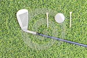 Golf club and golf ball on green grass