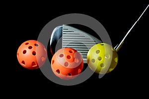 Golf Club and Plastic Practice Golf Balls on a Black Background