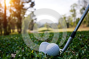 Golf clubs and golf balls on a green lawn in a beautiful golf course with morning sunshine. golf ball on green grass ready to hit