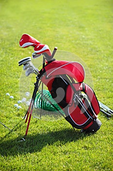 Golf clubs in golfbag, green grass background