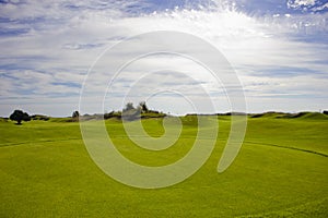 Golf course in Belek. Green grass on the field. Blue sky, sunny