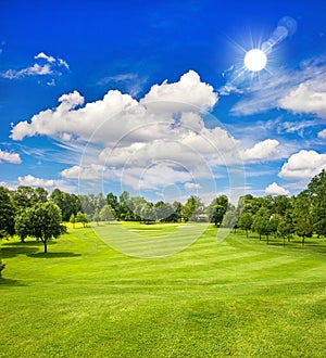 Golf course and blue sunny sky. green field landscape