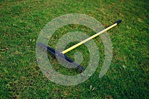 Golf course bunker rake on green grass