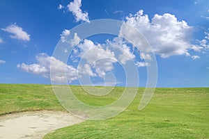 golf course - green golf field and sand pit with sky blue cloud