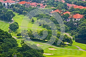 Golf course,with green trees and houses.