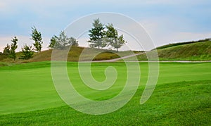 Golf course landscape. Golf course green grass, trees and blue sky nature background