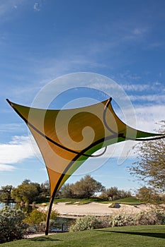 Golf course with a large sun shade in the desert against a blue sky