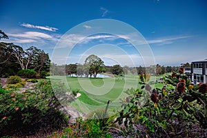 Golf course with lush green fairways and a lake in the background