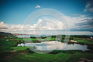 Golf course in luxury resort with players. Aerial view of golfer