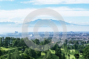 Golf course with misty Bandung cityscape background photo