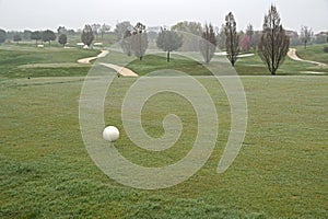 golf course in the morning with autumn mist .